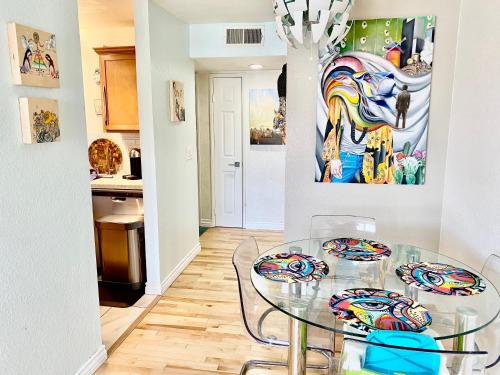 a dining room with a glass table and a painting at Artsy smart home near Downtown & Balboa Park in San Diego