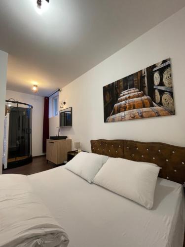 Un dormitorio con una cama blanca y una pintura en la pared en Captain YOO - Bénéc’ - App industriel sur le port, en Fécamp