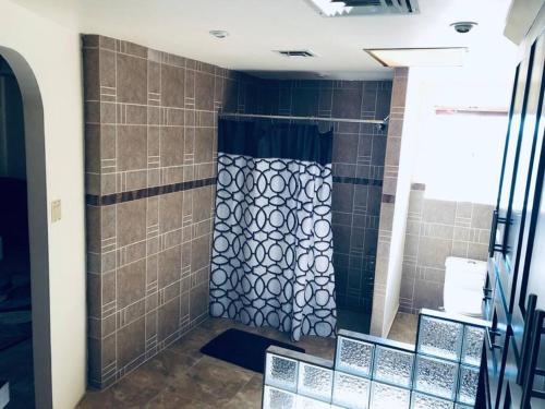 a shower in a bathroom with brown tile at Amplia casa en Colonia Campestre in Cananea