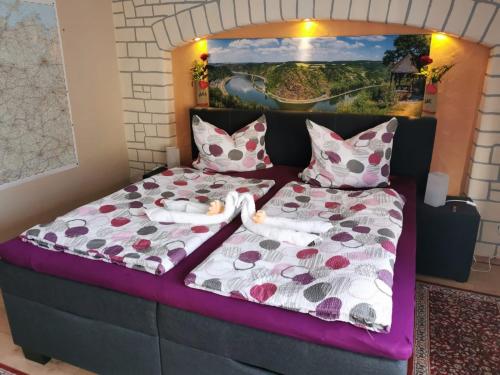 two dolls laying on a bed in a bedroom at Marktstübchen an der schönen Loreley in Bornich