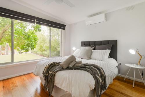 a bedroom with a large bed with a large window at Foam St Bliss in Rosebud