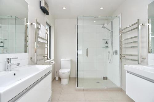 a bathroom with a shower and a sink and a toilet at Jeffreys Road - Christchurch Holiday Homes in Christchurch