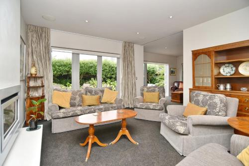 a living room with couches and a table at Jeffreys Road - Christchurch Holiday Homes in Christchurch