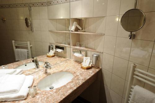 a bathroom with a sink and a mirror at AXXON Hotel in Brandenburg an der Havel