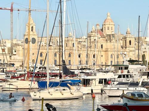 a group of boats docked in a harbor with a building at Entire House of Character - Castelinho Sao Marcos in Senglea