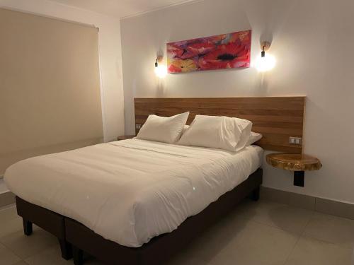 una camera da letto con un grande letto bianco e un tavolo di Cabañas Pachamama Casablanca a Casablanca
