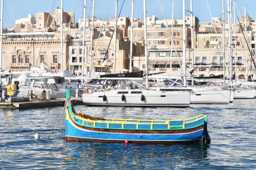 a boat sitting in the water with other boats at Entire House of Character - Castelinho Sao Marcos in Senglea