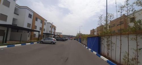 a car parked on the side of a street with buildings at Apartement haut standing avec piscine à la Marina Saidia in Saidia 