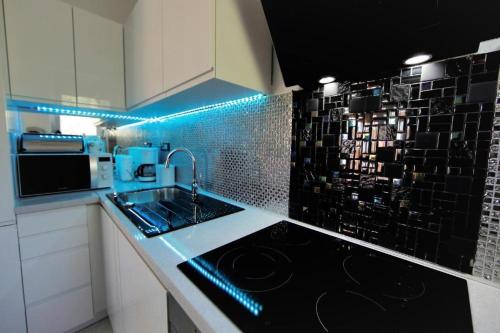 a kitchen with a sink and a counter with blue lights at Luxury Residence with jacuzzi-LONG ISLAND in Sali
