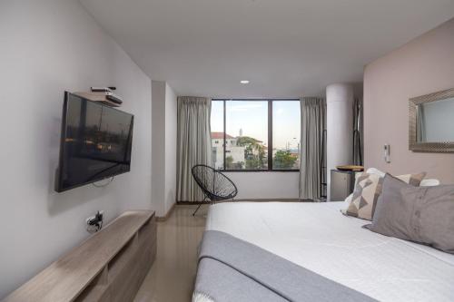 a bedroom with a bed and a tv on the wall at Bahari Cartagena Suites in Cartagena de Indias