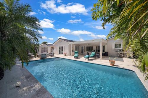 a swimming pool in front of a house with palm trees at Casa la Miami - Central location Villa with Pool & Gym in Miami