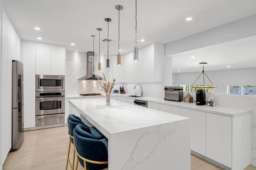 a white kitchen with a large white counter top at Casa la Miami - Central location Villa with Pool & Gym in Miami
