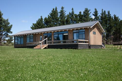 ein großes Haus mit einem großen Grasfeld in der Unterkunft White Rock Accommodation in Martinborough 
