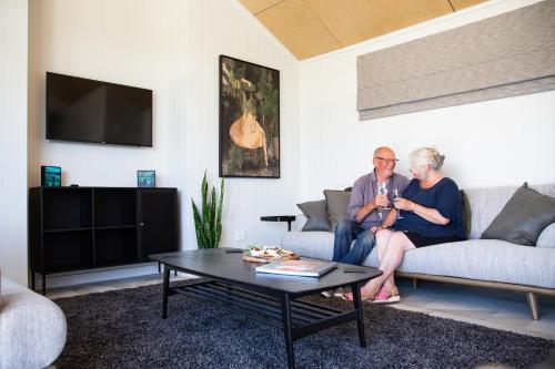two older people sitting on a couch in a living room at White Rock Accommodation in Martinborough 