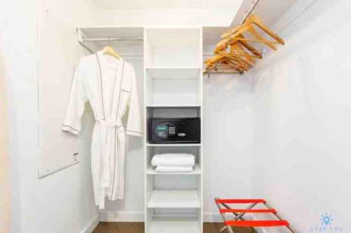 a closet with a white robe on a shelf at Modern apartment A - Beach Walk Resort in Hallandale Beach