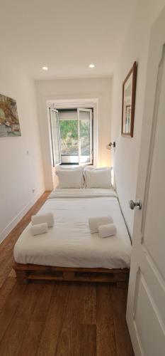 a large bed in a room with a window at S Soares Beato 6 3D in Lisbon