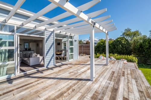 a white pergola on a wooden deck in a yard at Blue Bungalow in Martinborough 