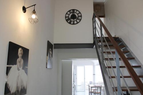 a staircase with a clock on the wall and a clock at Casa da Cal Branca in Évora