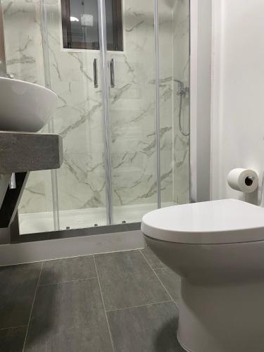 a bathroom with a shower and a toilet and a sink at Cabañas Pachamama Casablanca in Casablanca