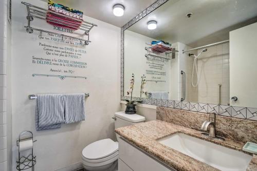 La salle de bains blanche est pourvue de toilettes et d'un lavabo. dans l'établissement Heart of Waikiki Marine Surf Waikiki Condo, à Honolulu