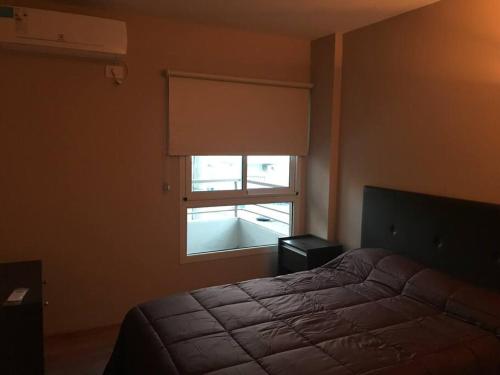Un dormitorio con una cama y una ventana con un ciego en Crespo 1548 1piso ascensor cochera en Rosario