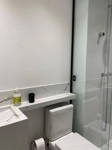 a bathroom with a toilet and a glass shower at Loft em prédio com piscina próximo da Oktoberfest Blumenau in Blumenau