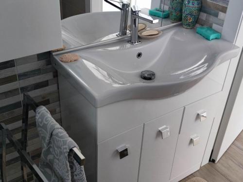 ein Badezimmer mit einem weißen Waschbecken und einem Spiegel in der Unterkunft Nice apartment in Sestriere with ski storage in Sestriere