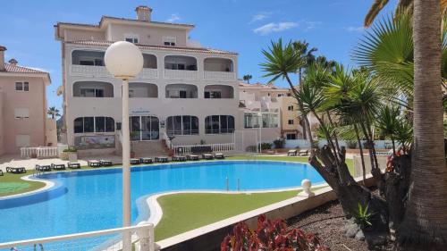 a resort with a swimming pool and a building at Chayofa Paraiso, apartamento Tenerife Sur in Chayofa