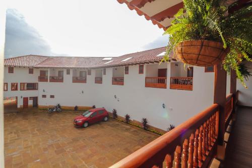 a red car parked in the courtyard of a building at Hotel las Palmas in Villa de Leyva