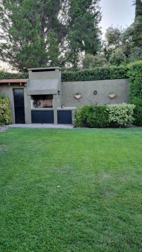 a house with a garage and a grass yard at Chacras de Coria Relax in Ciudad Lujan de Cuyo