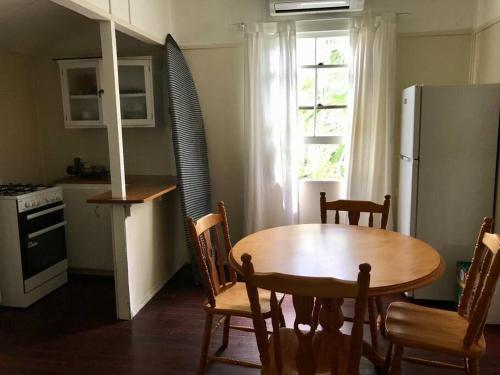 a kitchen with a table and chairs and a refrigerator at Original Surf Cottage in heart of Pottsville Beach in Pottsville