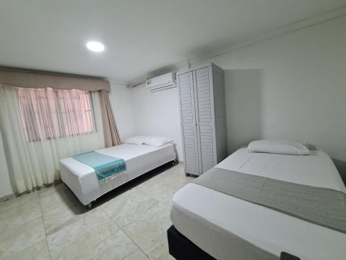 1 dormitorio con 2 camas y ventana en Posada Turística Miss Geidy, en San Andrés
