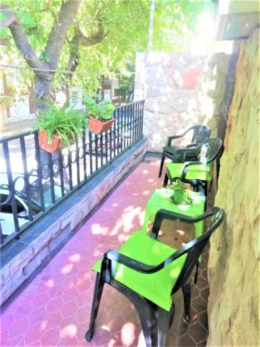 un grupo de mesas verdes y sillas en un balcón en COMODA SUITE EN UNA UBICACIÓN PRIVILEGIADA DE LA CIUDAD DE MENDOZA en Mendoza