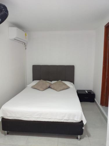a bedroom with a large bed with white sheets at Alojamiento San Felipe in Cartagena de Indias
