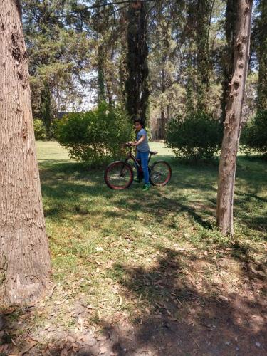 una persona che tiene una bicicletta in un parco di Casa de campo, a 3 minutos de Africam Safari. a Puebla