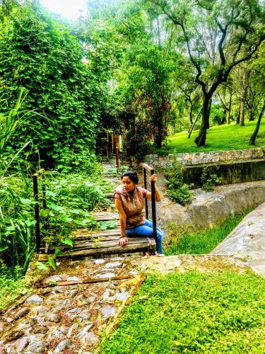 Un uomo seduto su una panchina in un parco di Casa de campo, a 3 minutos de Africam Safari. a Puebla