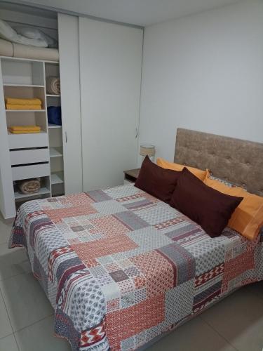 a bedroom with a bed with a quilt on it at Nikemen, moderno dpto con patio y cochera cubierta in Neuquén