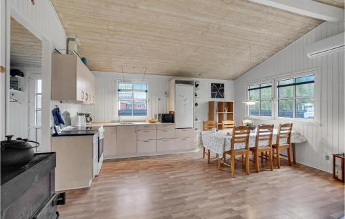una cucina con mobili bianchi, tavolo e sedie di 3 Bedroom Beautiful Home In Højslev a Højslev
