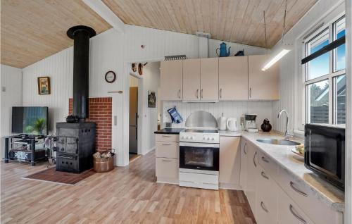 a kitchen with white cabinets and a stove top oven at 3 Bedroom Beautiful Home In Højslev in Højslev