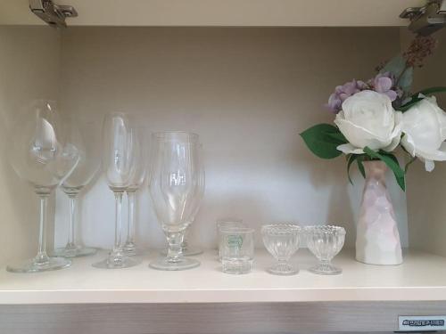 a shelf with wine glasses and a vase with flowers at AREX Hongik univ Unit 201 in Seoul