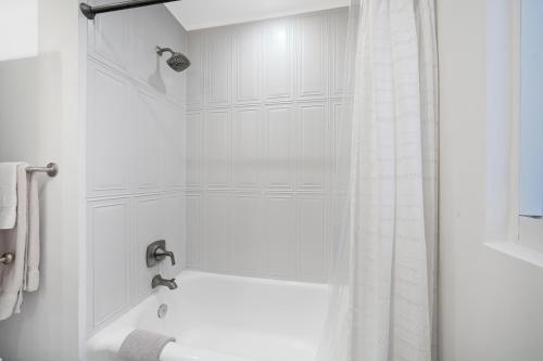 a bathroom with a shower with a white shower curtain at Miami Art Deco Home By Pmi in Miami