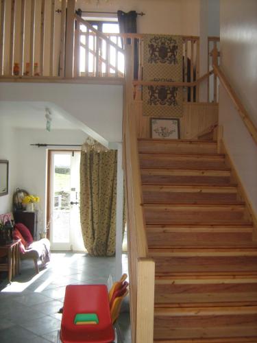 a staircase in a living room with a red stool at Slemish Barn Hostel in Ballymena