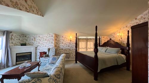 a bedroom with a bed and a couch and a fireplace at Bedham Hall B&B in Niagara Falls
