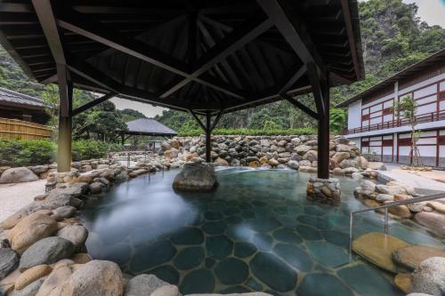 a pool of water with rocks in front of a building at Yoko Onsen Quang Hanh in Cẩm Phả