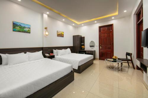 Sóc SơnにあるHanoi Airport Suitesのベッド2台とテレビが備わるホテルルームです。