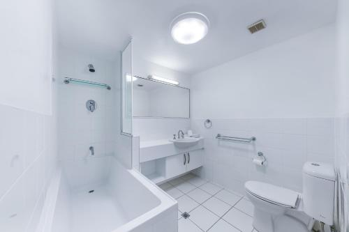 エアリービーチにあるAirlie Ocean Paradiseのトイレと洗面台を備えた白いバスルーム