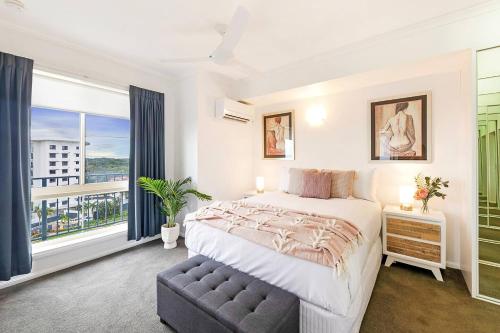 een slaapkamer met een groot bed en een groot raam bij Captain's Lookout - Penthouse Living at Cullen Bay in Larrakeyah