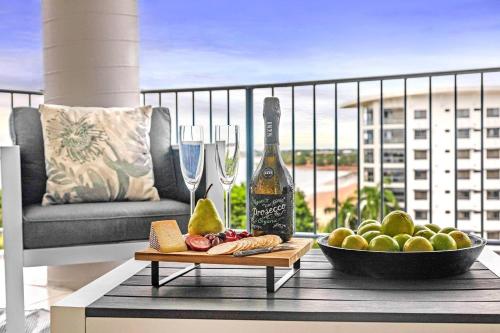 a bottle of wine and a bowl of food on a table at Captain's Lookout - Penthouse Living at Cullen Bay in Darwin