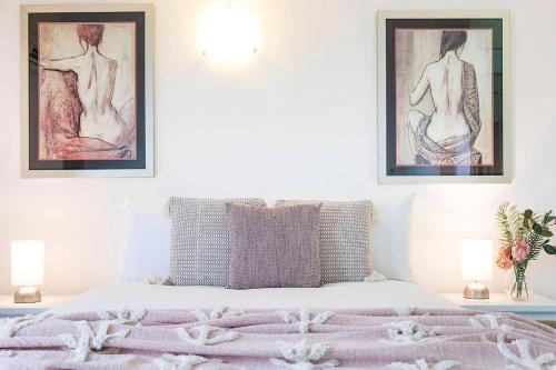 a bedroom with a bed with two pictures on the wall at Captain's Lookout - Penthouse Living at Cullen Bay in Darwin