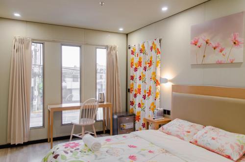 a bedroom with a bed and a desk and a window at Moriyama Hotel in Mandaue City